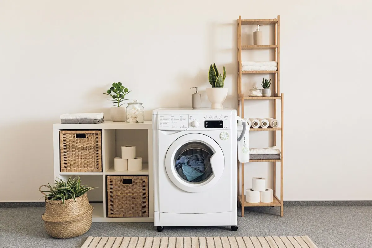 Washing machine beside a compact laundry cabinet and shelving